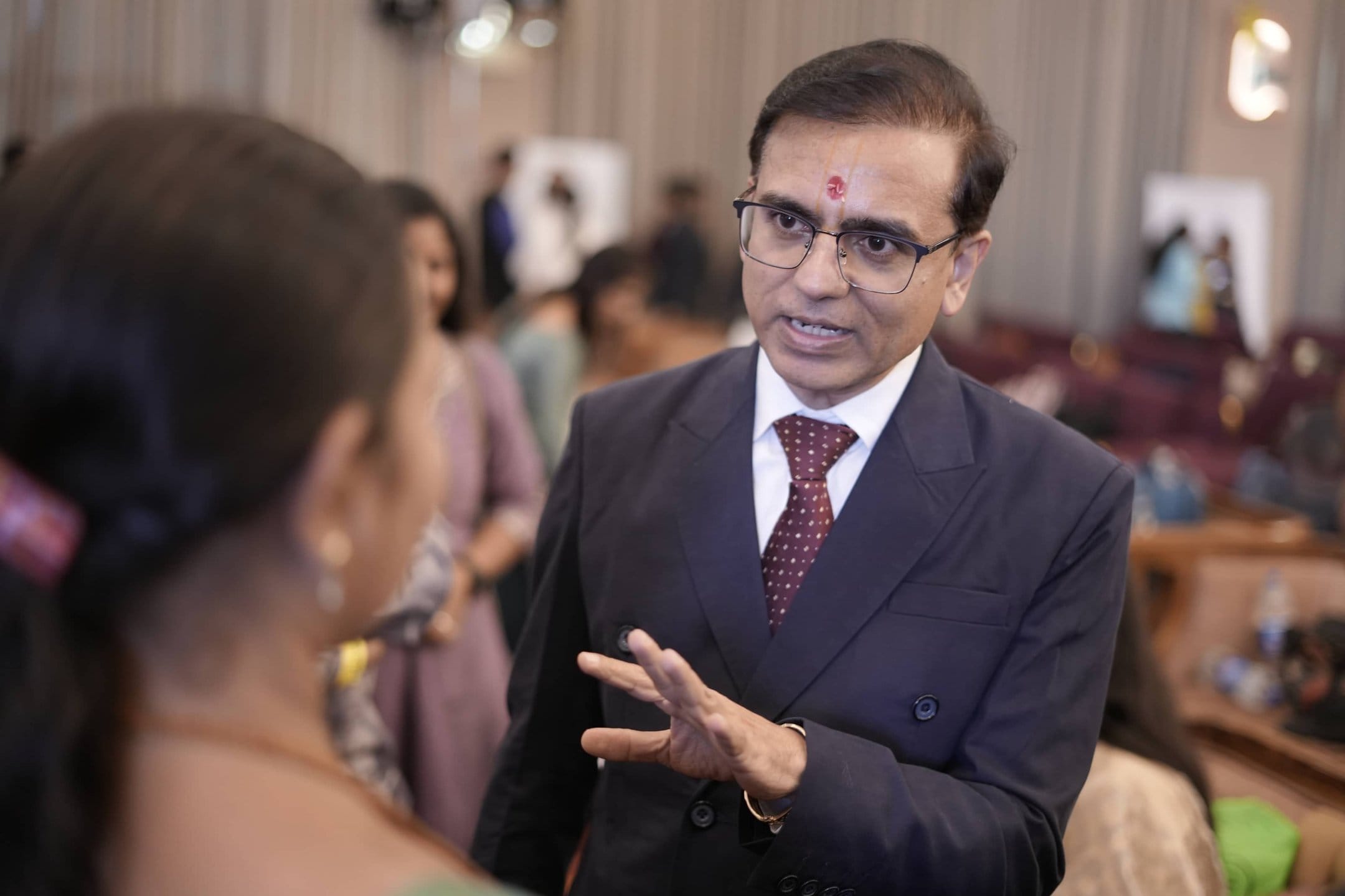 Amit Sarvaiya speaking with a community member at a health and wellness gathering in Surat