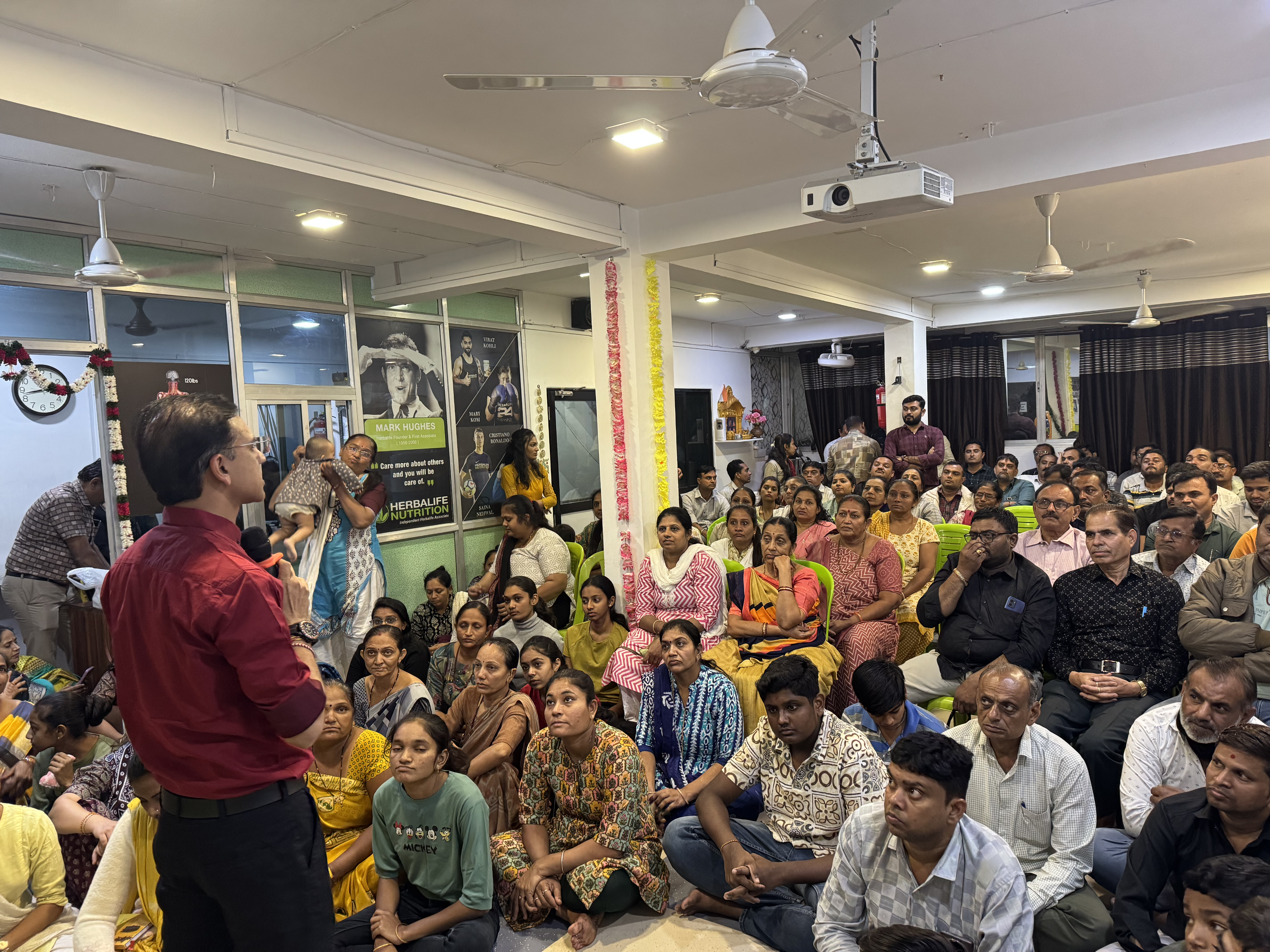 Amit Sarvaiya addressing a large audience at a community health awareness session